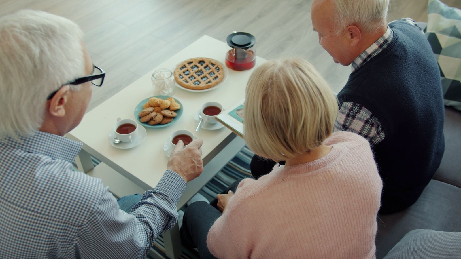 Older friends gathered together over tea and cookies