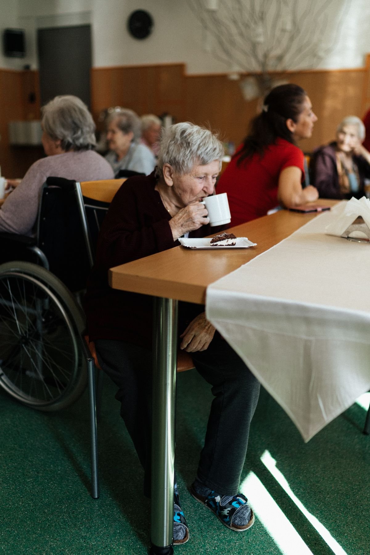 A group of older adults enjoying tea and cake together at a community gathering