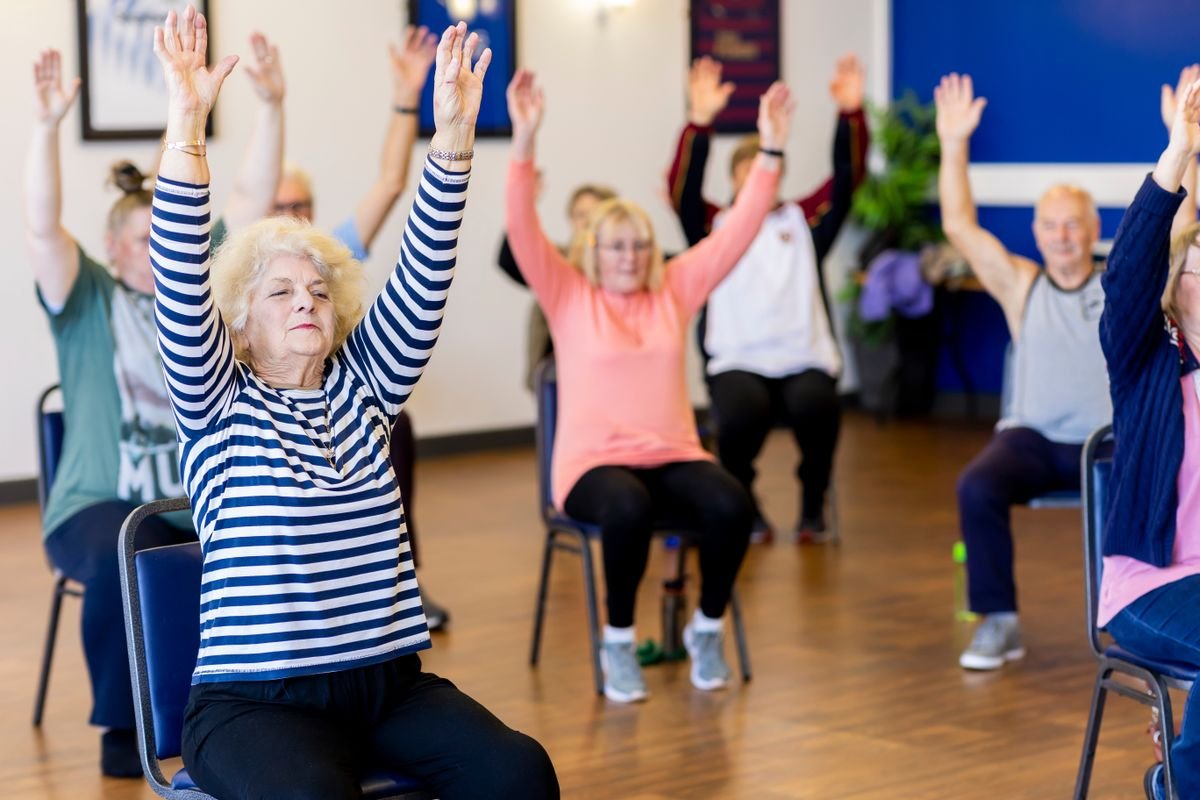 Older adults taking part in a chair exercise session